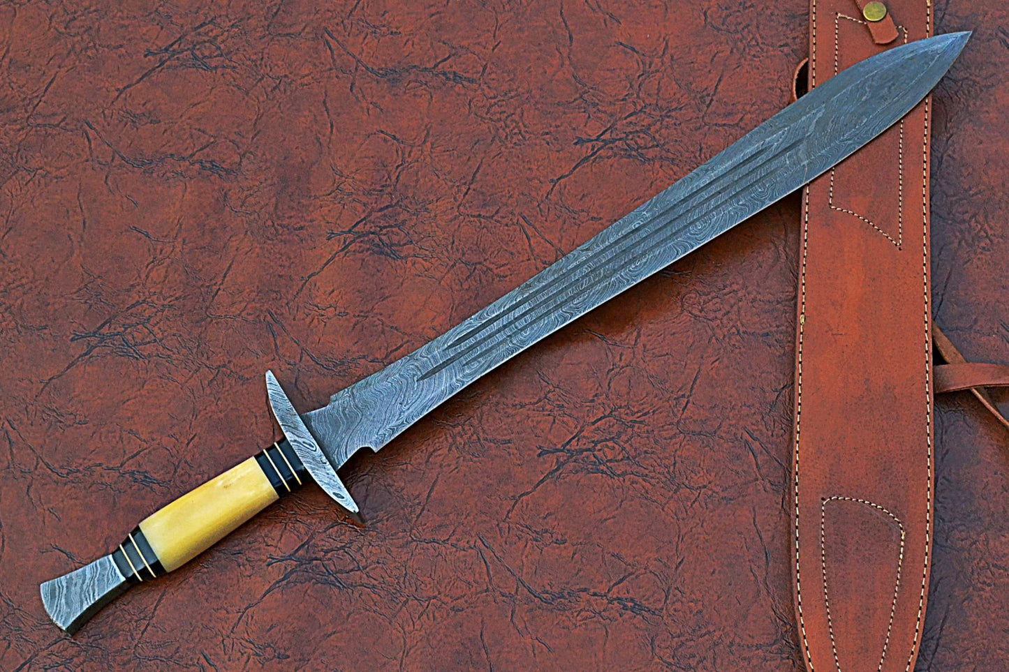 27" Long Sting Sword, 19" Long Hand Forged Damascus Steel Double Edge Blade with Triple Blood Groove, Brass Cross hilt Forward and Pommel, Damascus Guard & Pommel, Camel Bone Grip, Leather Scabbard