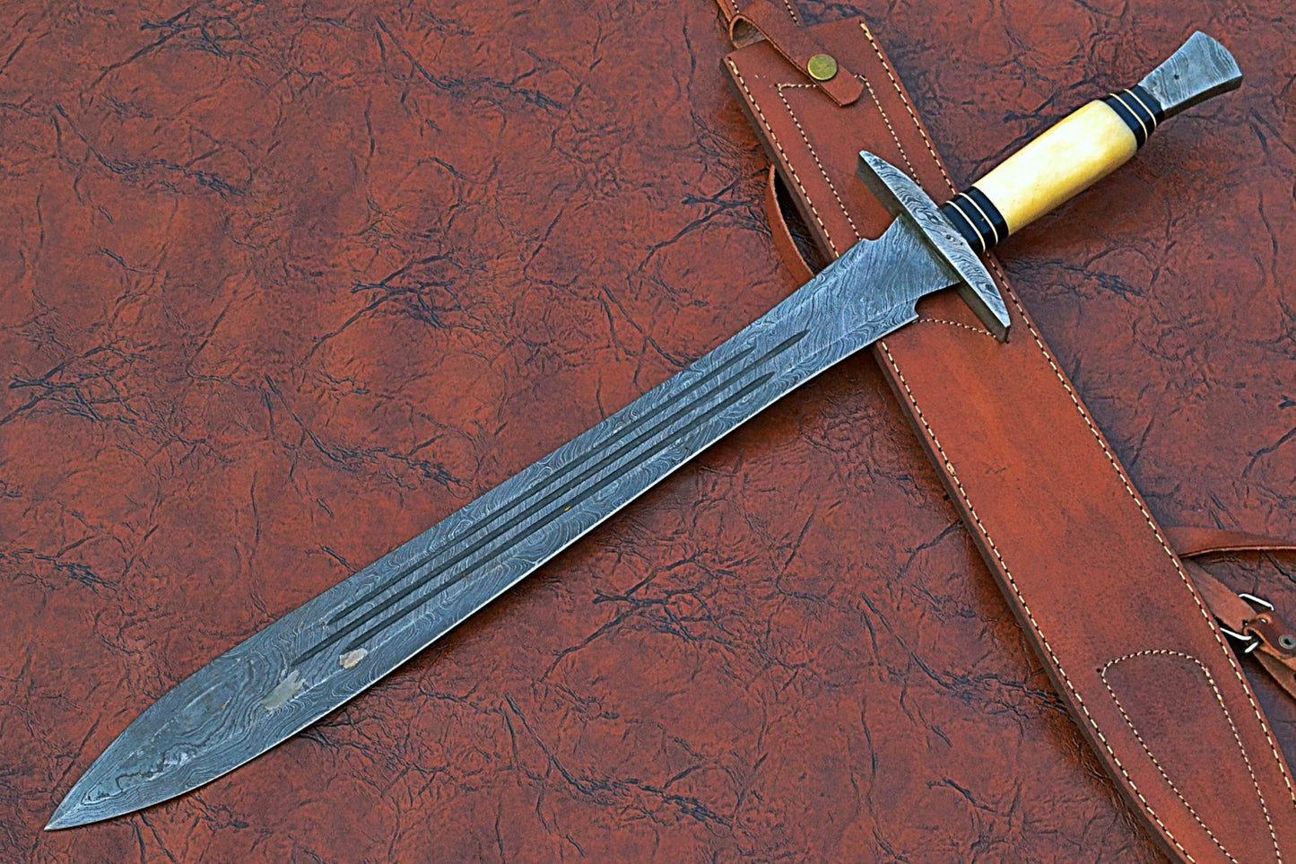 27" Long Sting Sword, 19" Long Hand Forged Damascus Steel Double Edge Blade with Triple Blood Groove, Brass Cross hilt Forward and Pommel, Damascus Guard & Pommel, Camel Bone Grip, Leather Scabbard
