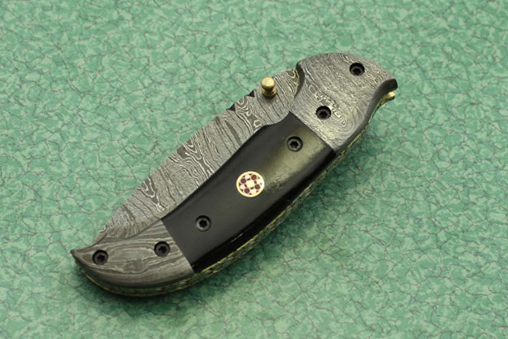 8 Inch Damascus steel folding knife, Available in Bone, Bull horn and Ram scales with Damascus bolster, Equipped with Thumb closing knob and liner lock, Cow hide Leather sheath with belt loop