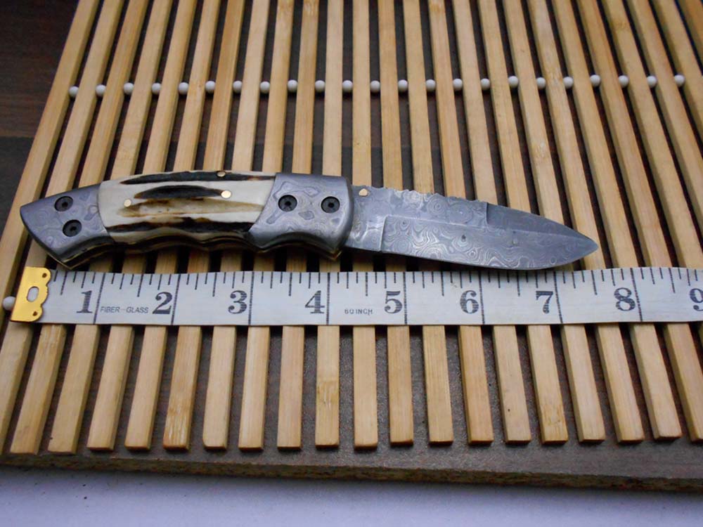 7.5" Damascus folding knife with Damascus bolster on both edges with thumb knob & liner lock equipped, Available in 4 scales, Cow hide leather sheath with belt loop included