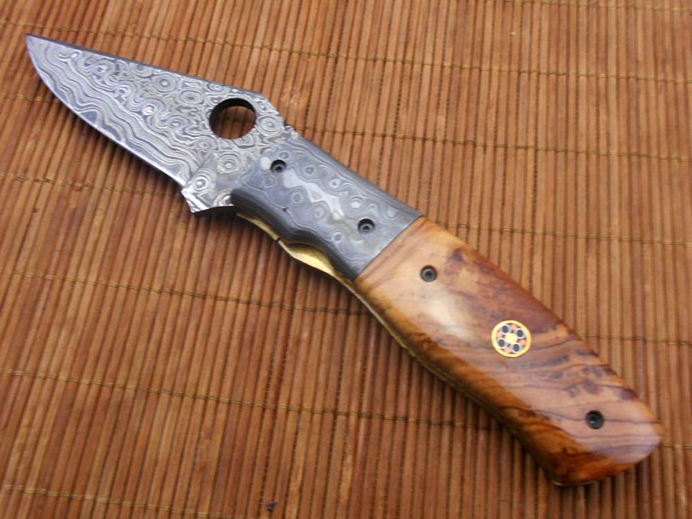 7.5" flat scale folding knife, Damascus steel blade with finger hole, Equipped with liner lock, Available in Wood & Horn scales, Leather sheath included