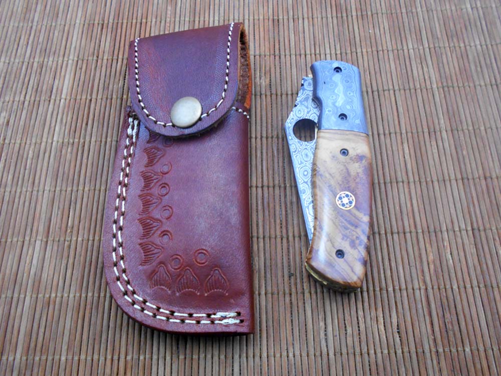 7.5" flat scale folding knife, Damascus steel blade with finger hole, Equipped with liner lock, Available in Wood & Horn scales, Leather sheath included