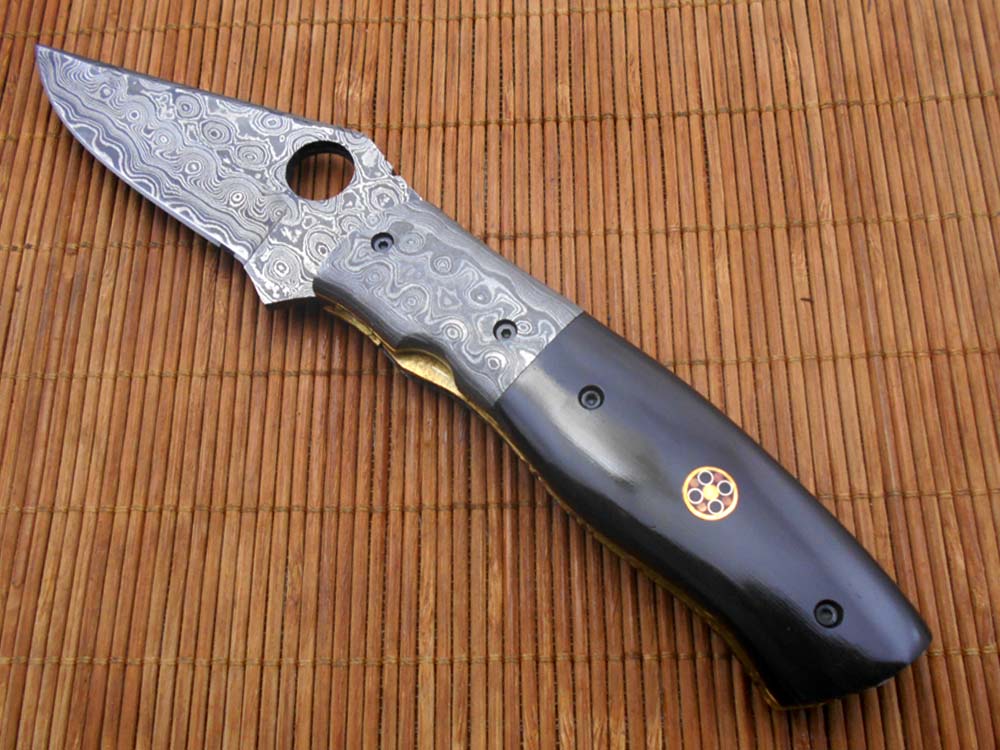 7.5" flat scale folding knife, Damascus steel blade with finger hole, Equipped with liner lock, Available in Wood & Horn scales, Leather sheath included