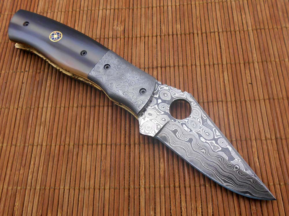7.5" flat scale folding knife, Damascus steel blade with finger hole, Equipped with liner lock, Available in Wood & Horn scales, Leather sheath included