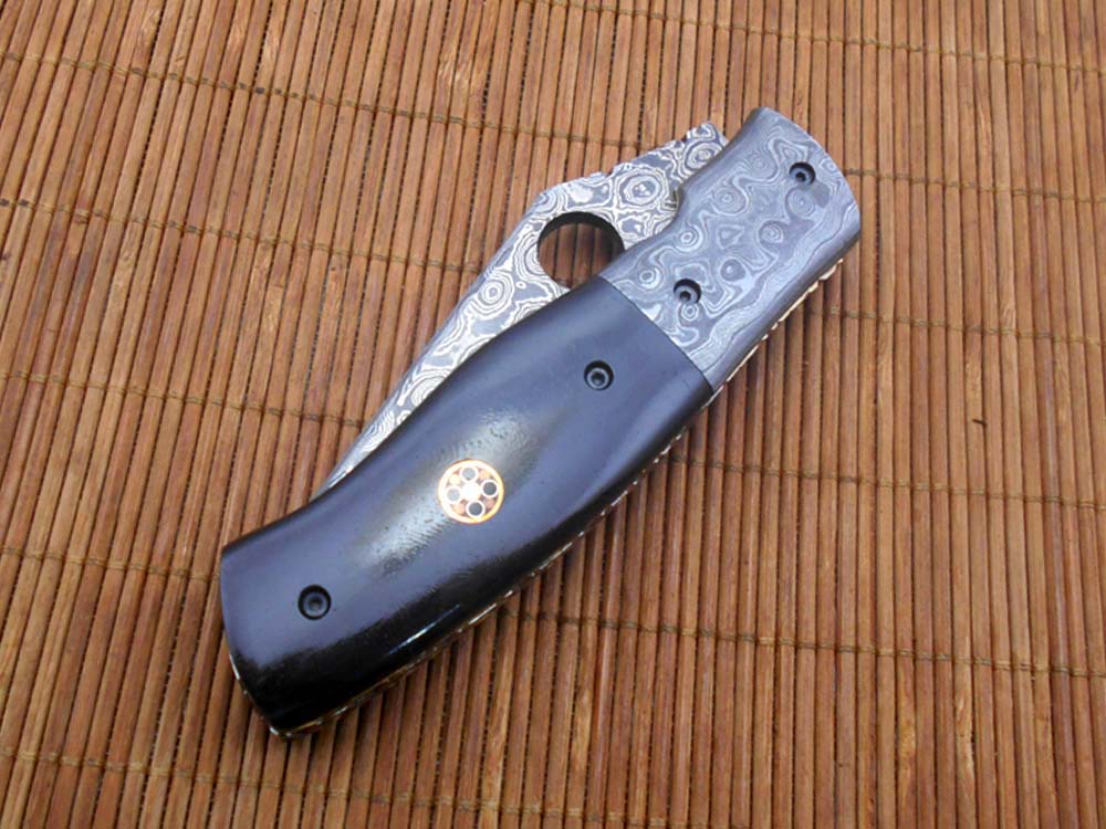 7.5" flat scale folding knife, Damascus steel blade with finger hole, Equipped with liner lock, Available in Wood & Horn scales, Leather sheath included