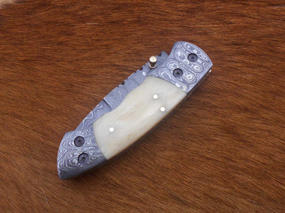 7.5" Damascus folding knife with Damascus bolster on both edges with thumb knob & liner lock equipped, Available in 4 scales, Cow hide leather sheath with belt loop included