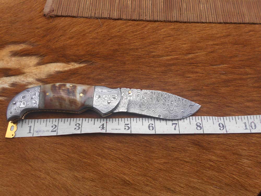 8 Inch Damascus steel folding knife, Available in Bone, Bull horn and Ram scales with Damascus bolster, Equipped with Thumb closing knob and liner lock, Cow hide Leather sheath with belt loop
