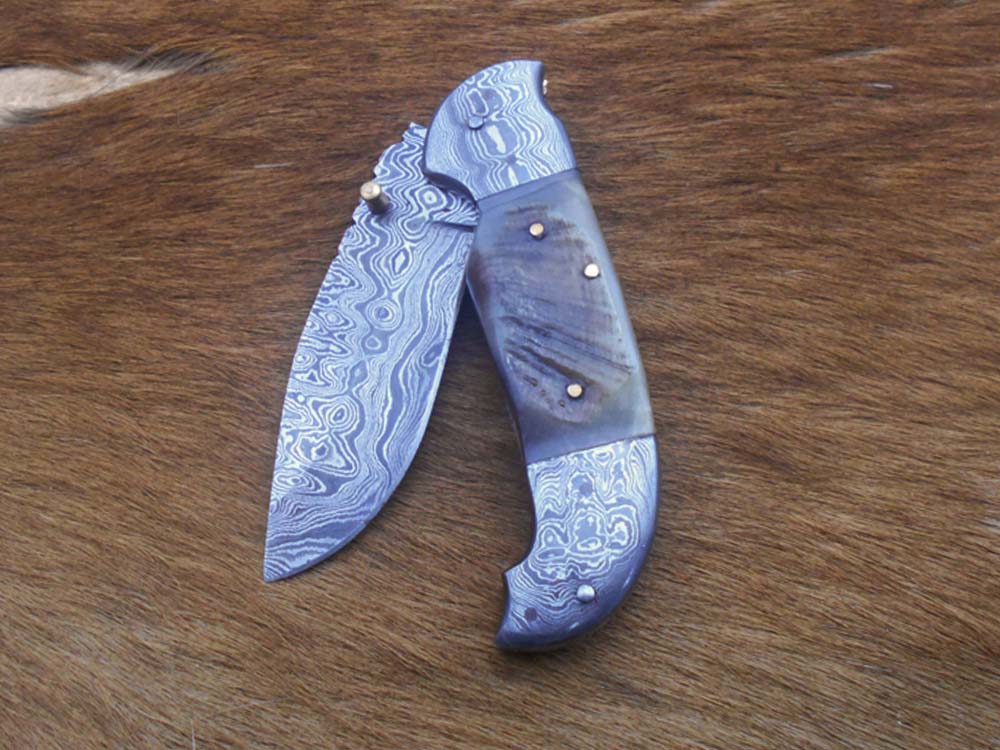 8 Inch Damascus steel folding knife, Available in Bone, Bull horn and Ram scales with Damascus bolster, Equipped with Thumb closing knob and liner lock, Cow hide Leather sheath with belt loop