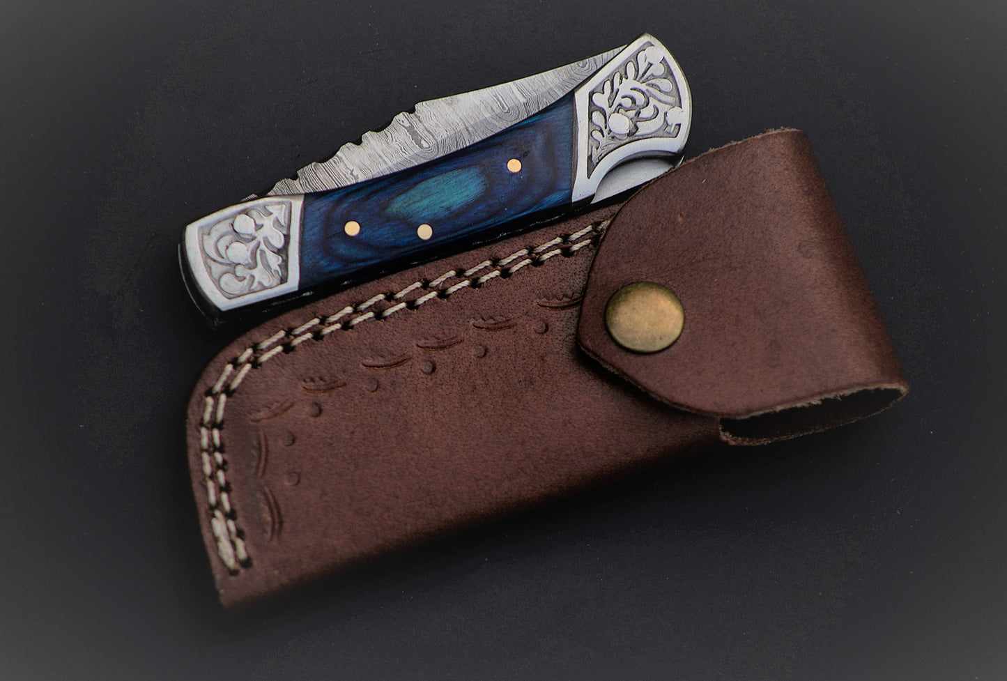 7" long back lock Folding Knife, Blue wood Scale with Engraved steel bolster, custom made 3.25" Hand Forged Damascus steel blade, Cow hide leather sheath with belt loop